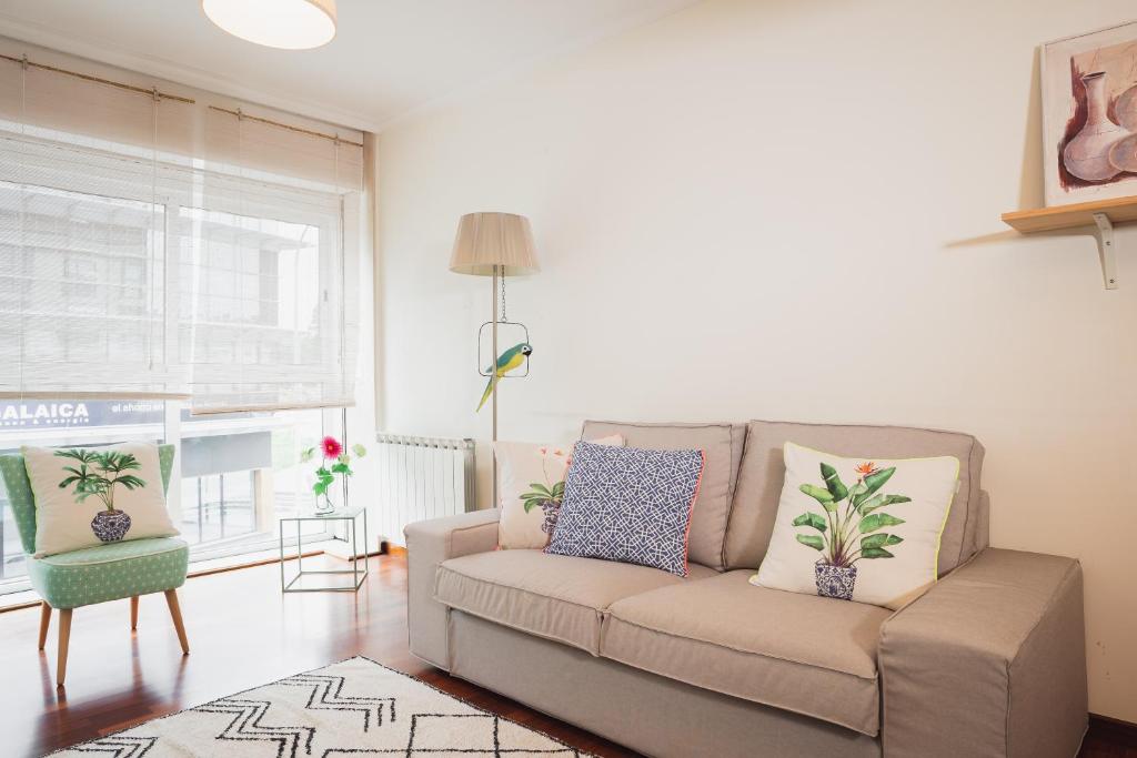 uma sala de estar com um sofá e uma janela em Apartamentos LÓRIEN Milladoiro em Milladoiro