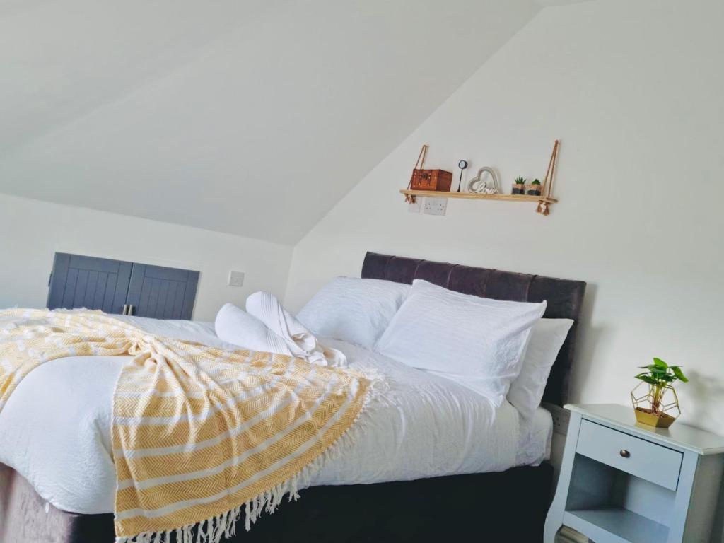 een slaapkamer met een bed met witte lakens en een tafel bij 3 bedroom apartment near Birmingham airport/NEC in Birmingham
