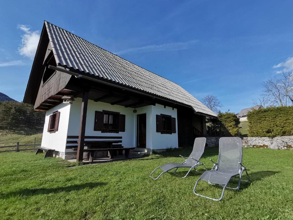 two chairs sitting in front of a house at Počitniška hiša Uskovnica in Srednja Vas v Bohinju