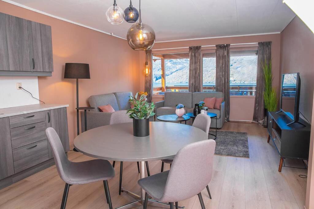 a kitchen and living room with a table and chairs at Vestly in Etnesjøen