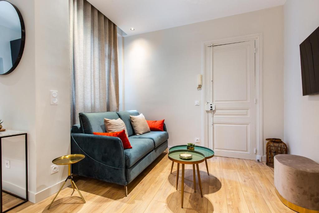 a living room with a blue couch and a table at CMG BASTILLE / GARE DE LYON 2 in Paris