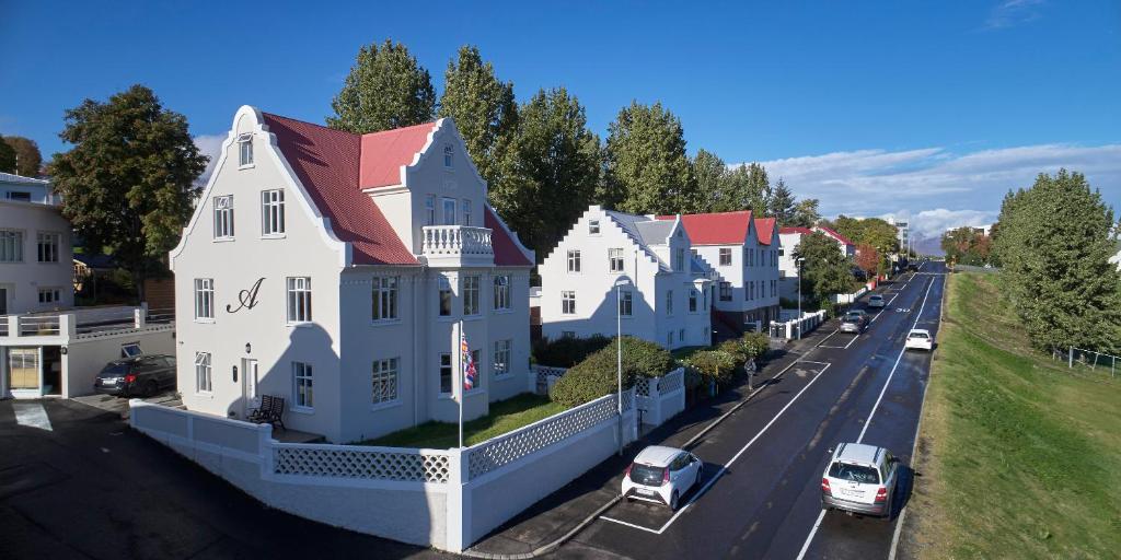 eine Reihe von Häusern in einer Stadtstraße mit Autos in der Unterkunft Akurinn Residence in Akureyri