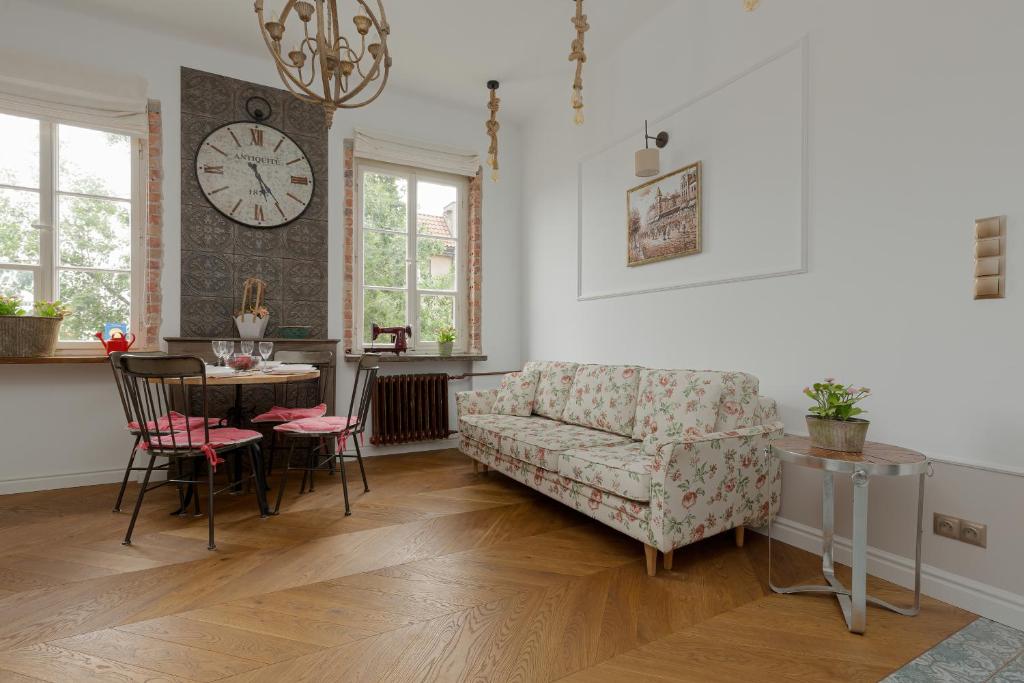 uma sala de estar com um sofá, uma mesa e um relógio em Apartment on the Warsaw Square by Renters em Varsóvia