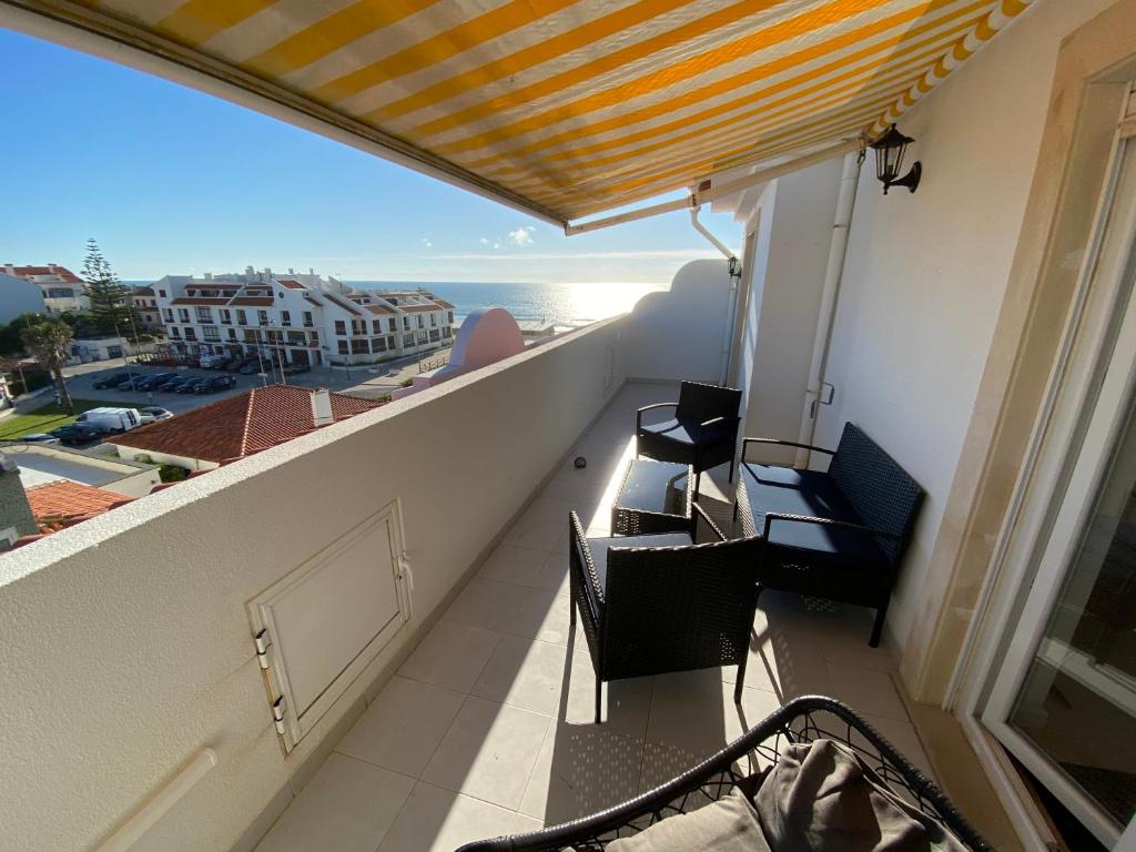 a balcony with chairs and a view of the ocean at Casa Melli with Sunset Oceanview Terrace in Lourinhã