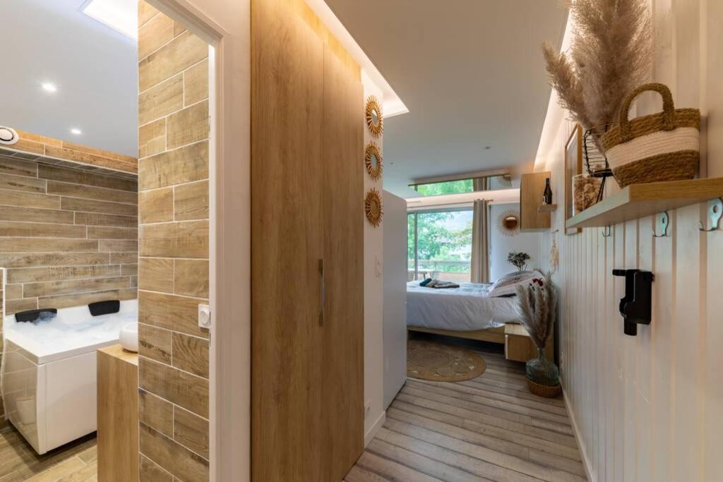 a bathroom with a walk in shower and a bedroom at LE QUINTESSENCE: Balnéo & Luminothérapie + parking in Voiron