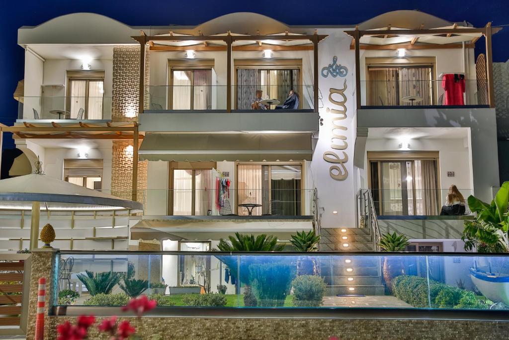 a building with a swimming pool in front of it at Elimia Suites & Studios in Makry Gialos