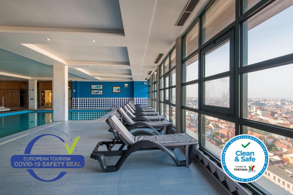 a row of benches in a building with a pool at Vila Gale Porto - Centro in Porto