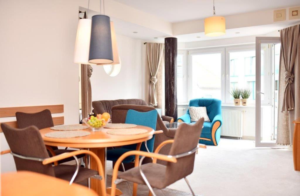 a living room with a table and chairs at Apartament Porto in Kołobrzeg
