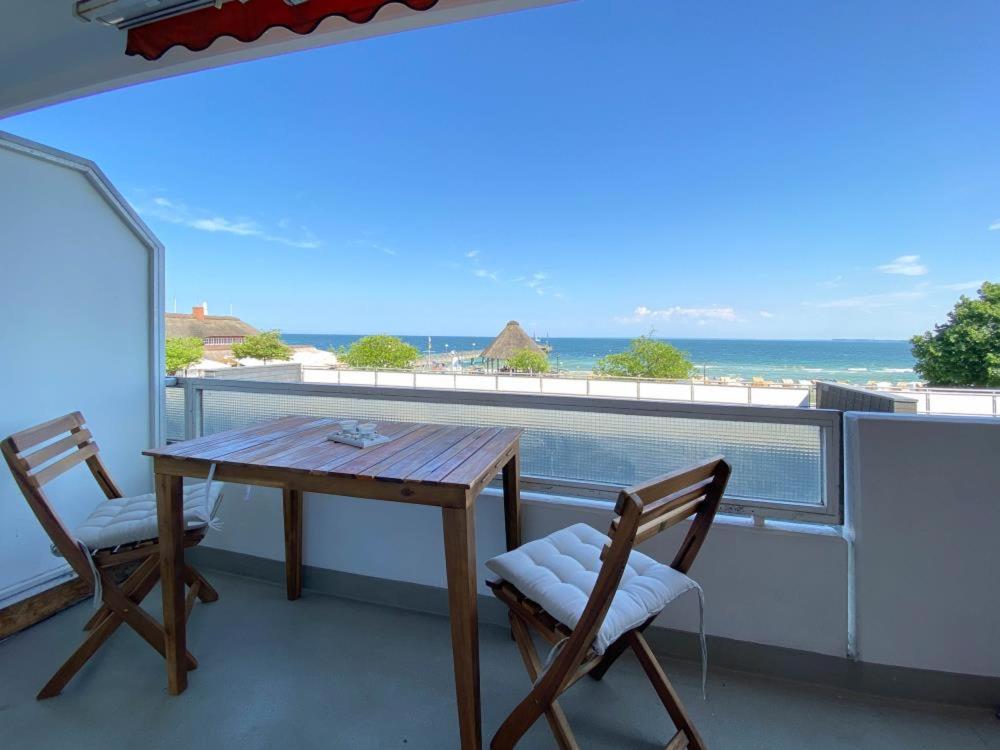 een tafel en stoelen op een balkon met uitzicht op de oceaan bij Ferienwohnung Muschelsucher in Haffkrug