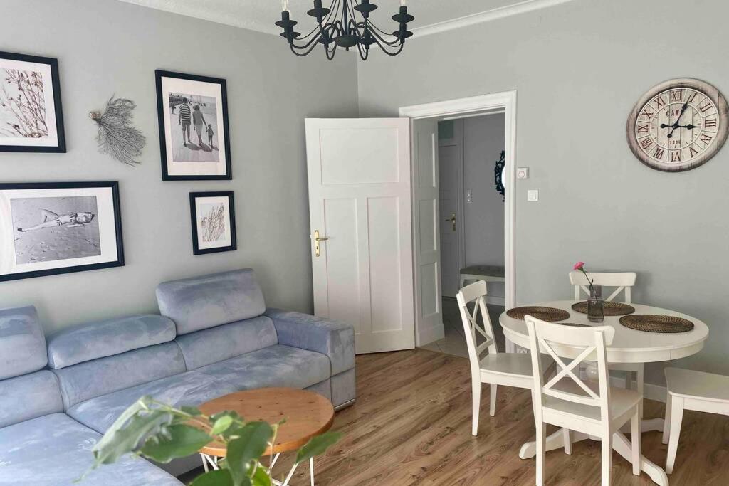 een woonkamer met een blauwe bank en een tafel bij ApartSea 2 Gdynia in Gdynia