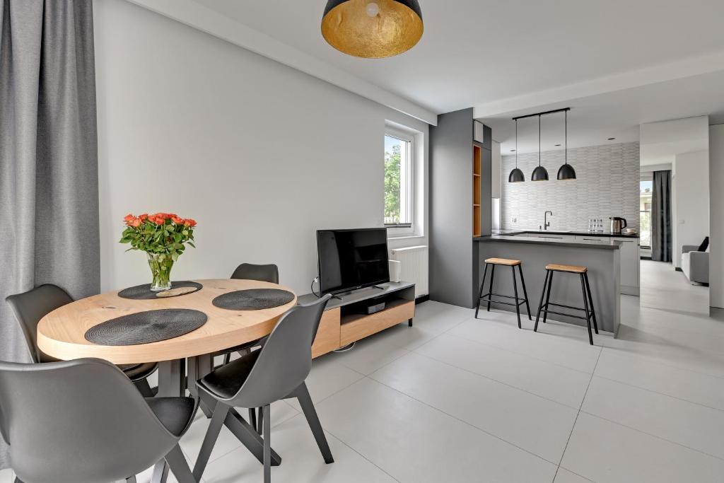 a kitchen and dining room with a table and chairs at Comfort Apartments Navio in Gdańsk