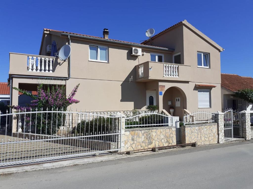 a house with a fence in front of it at Apartmani Sanda i Leo in Bibinje