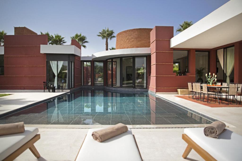 an exterior view of a house with a swimming pool at Villa LOULA in Marrakesh