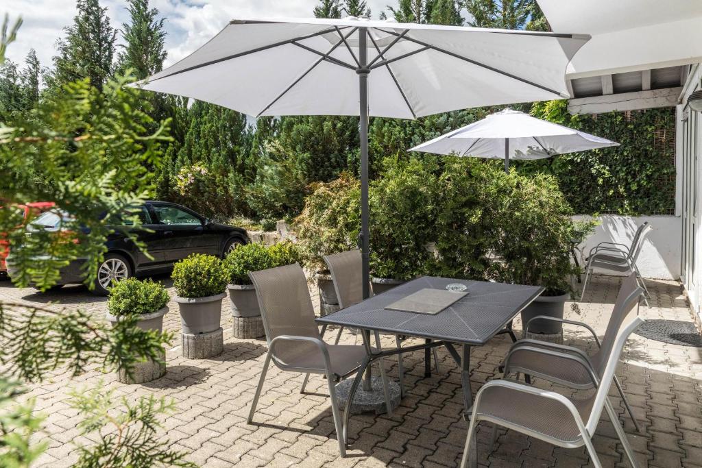 a table and chairs with an umbrella on a patio at Fewo Eg Mitte - Hunde erlaubt in Oberteuringen