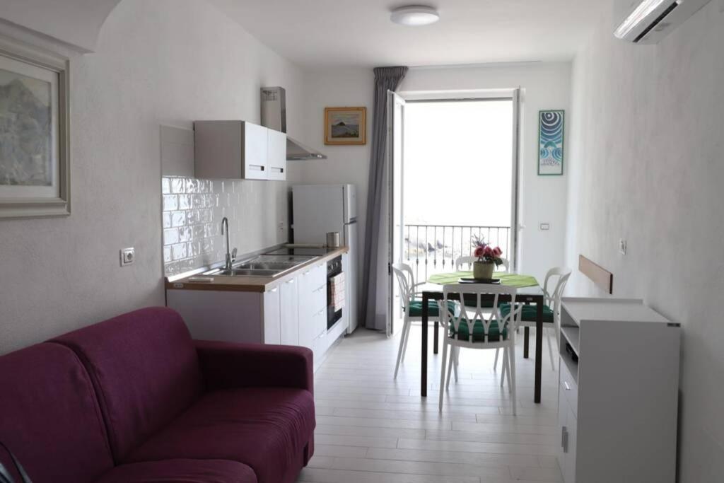 a kitchen with a couch and a table in a room at Casa Maadry in Ischia