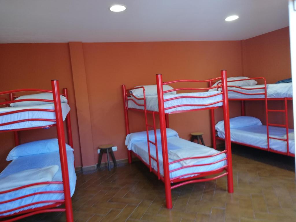 three red bunk beds in a room with a wall at O Encontro in Fisterra