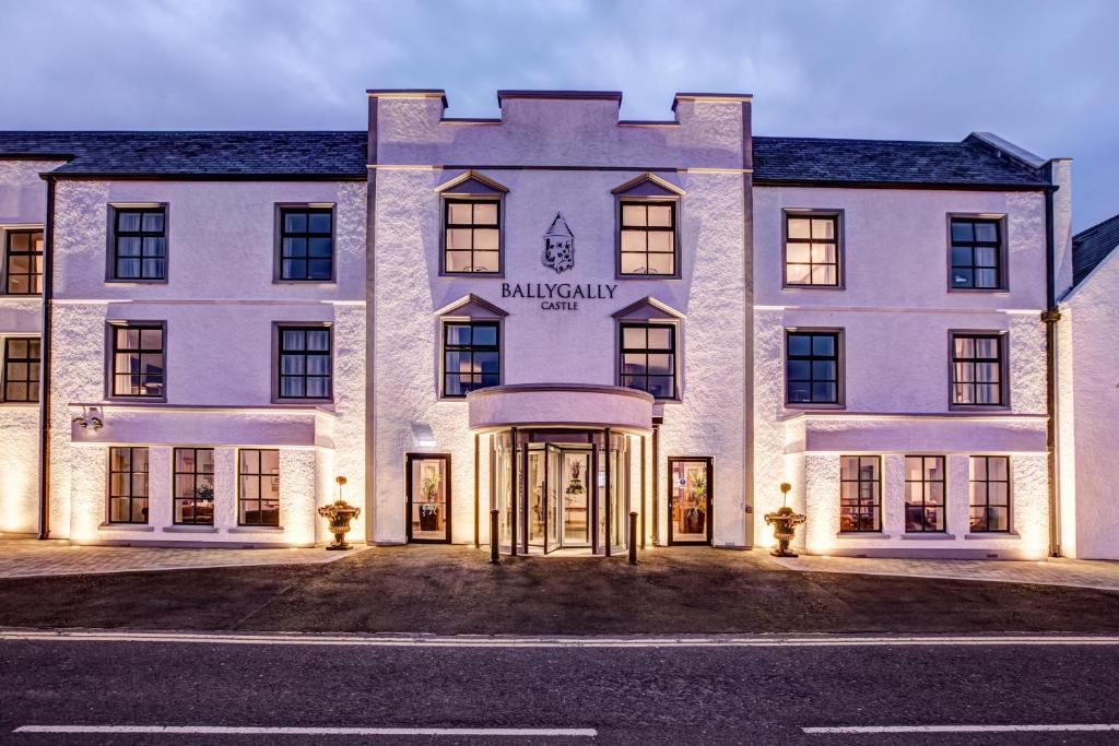 a large white building with the front door lit up at Ballygally Castle in Larne