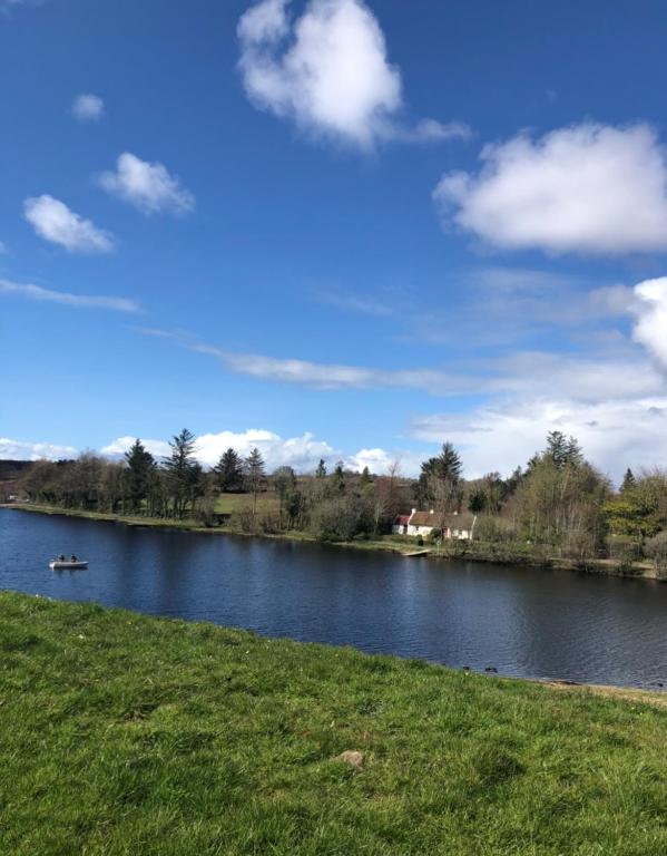 a lake with a boat in the water at Keenaghan Cottage Belleek Fermanagh Northern Ireland in Belleek
