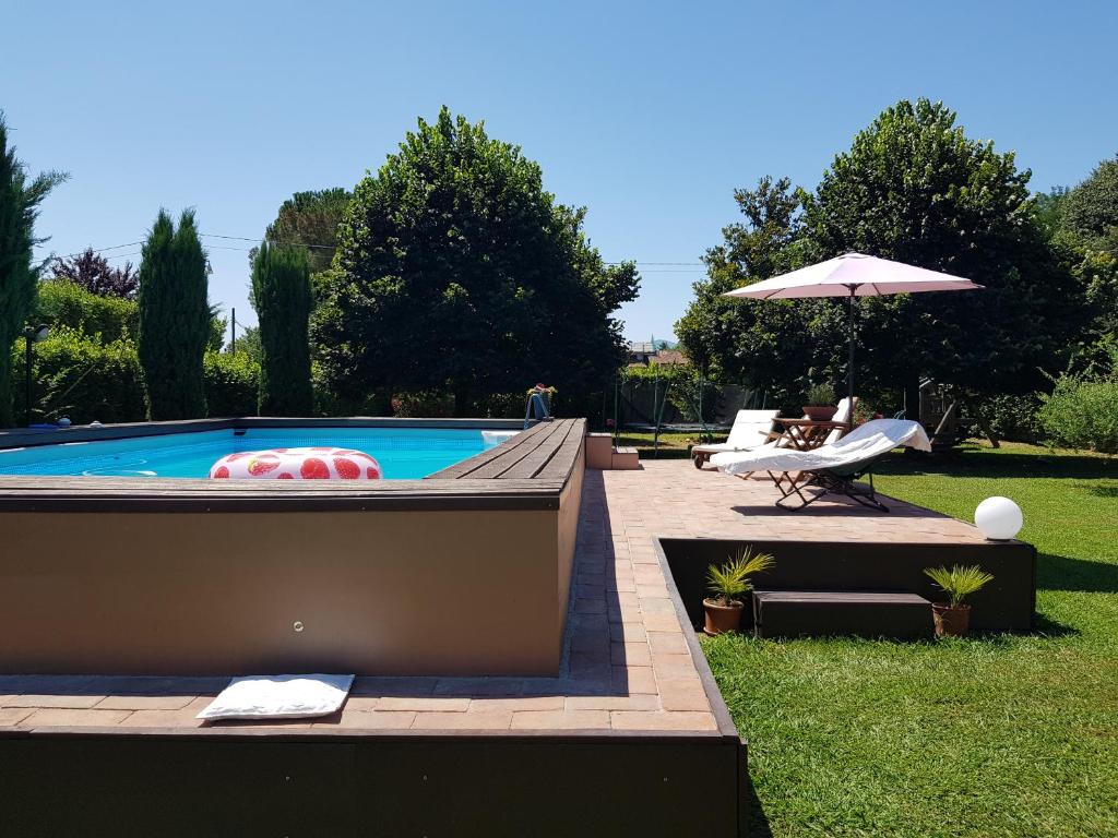 - Piscina con silla y sombrilla en Il Casale en Lucca