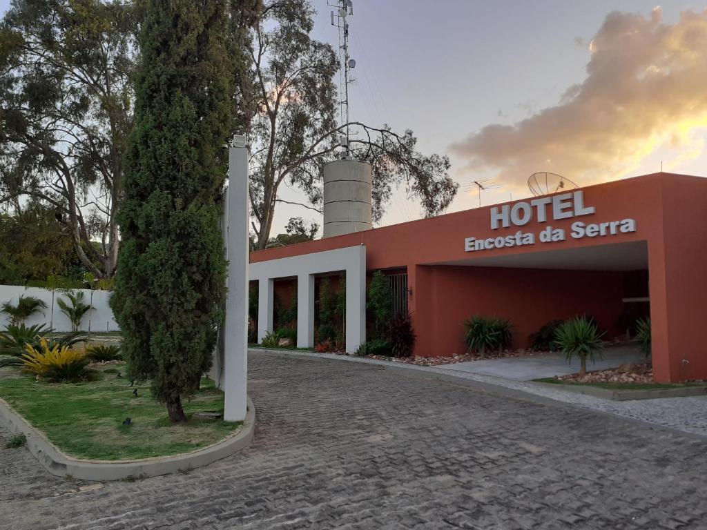 a hotel with a sign in front of a building at Hotel Encosta da Serra CRATO CE in Crato