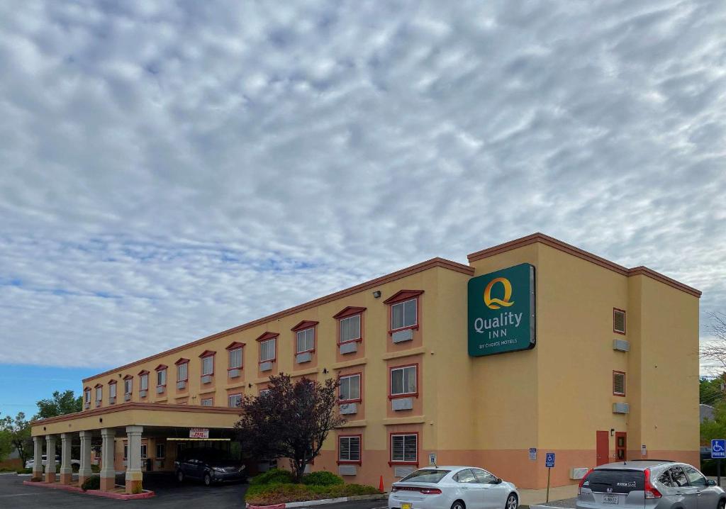 a large yellow building with a sign on it at Quality Inn Albuquerque East I-40 Juan Tabo Exit in Albuquerque