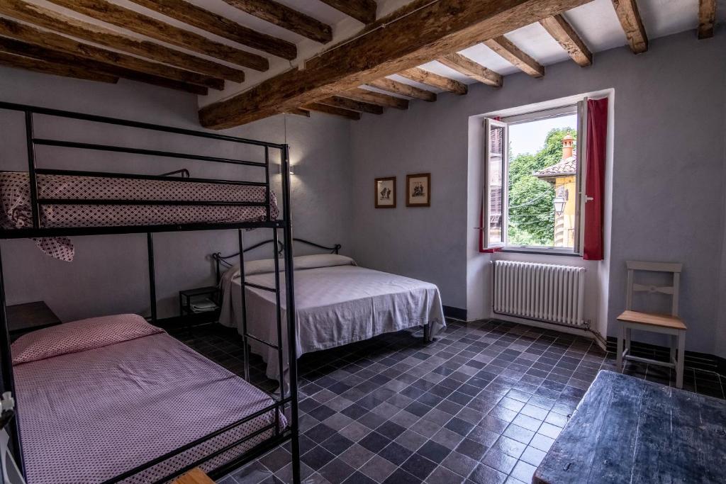 1 dormitorio con 2 literas y ventana en WineBikeHostel, en Rocca Grimalda