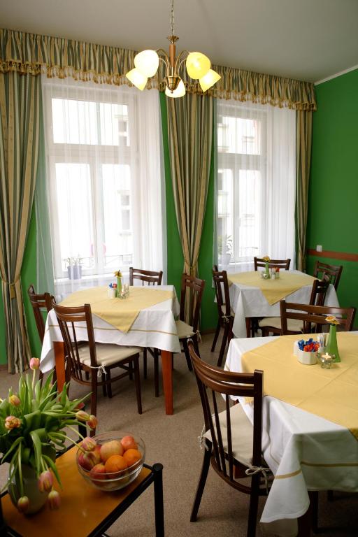 a restaurant with tables and chairs and green walls at Hotel Boston in Karlovy Vary