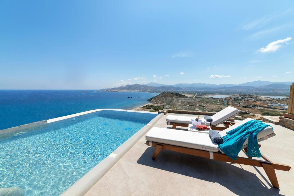 a swimming pool with a view of the ocean at Naxos Rock Villas in Stelida