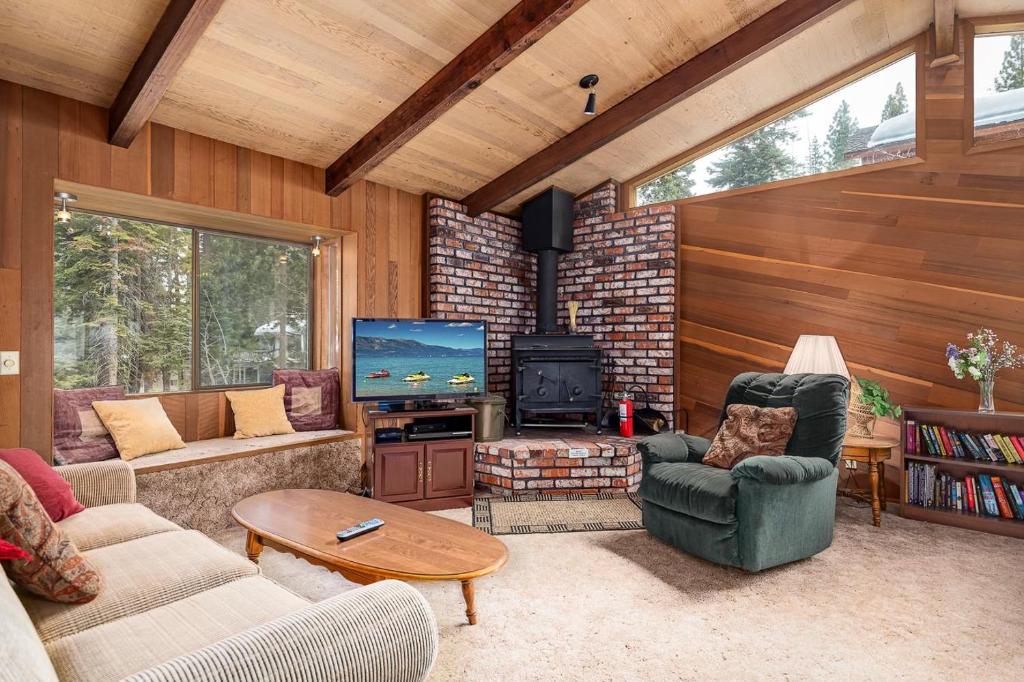 sala de estar con sofás, TV y chimenea en The Villa Bossi, en Carnelian Bay