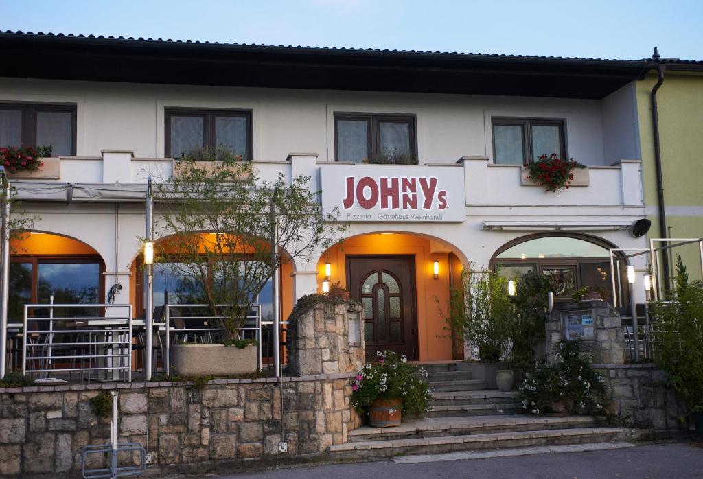 濱湖波德斯多夫的住宿－Gästehaus Weinhandl & Johnnys Pizzeria，带有读慢跑标志的建筑