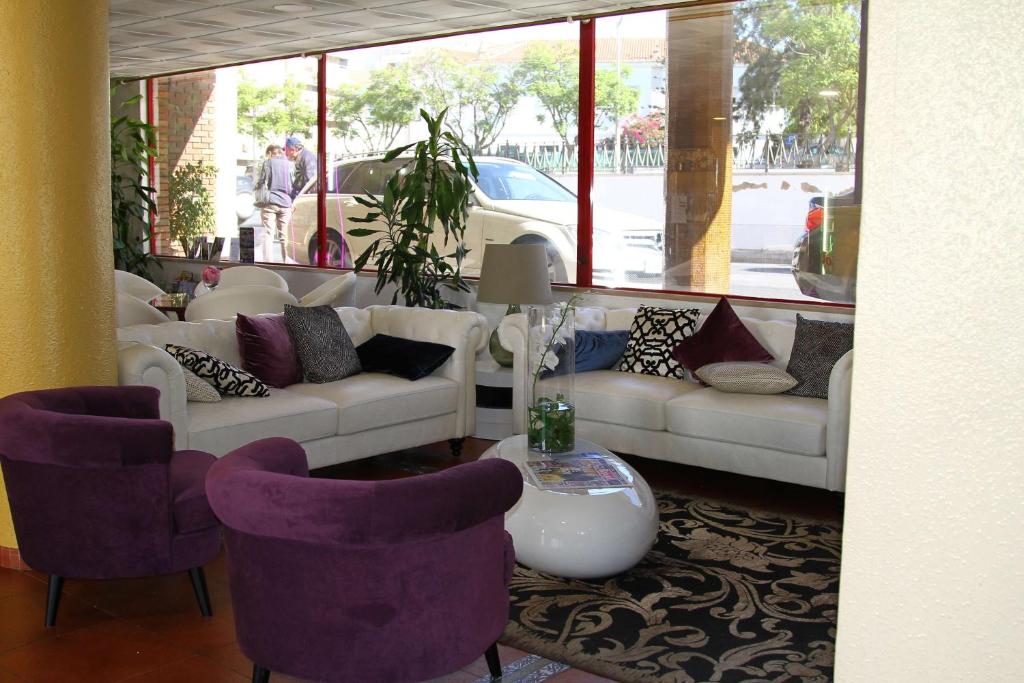 a living room with white couches and purple chairs at Best Western Hotel Dom Bernardo in Faro