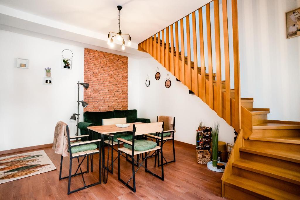 una sala da pranzo con tavolo e sedie di Galeria Grafit Apartments a Sibiu