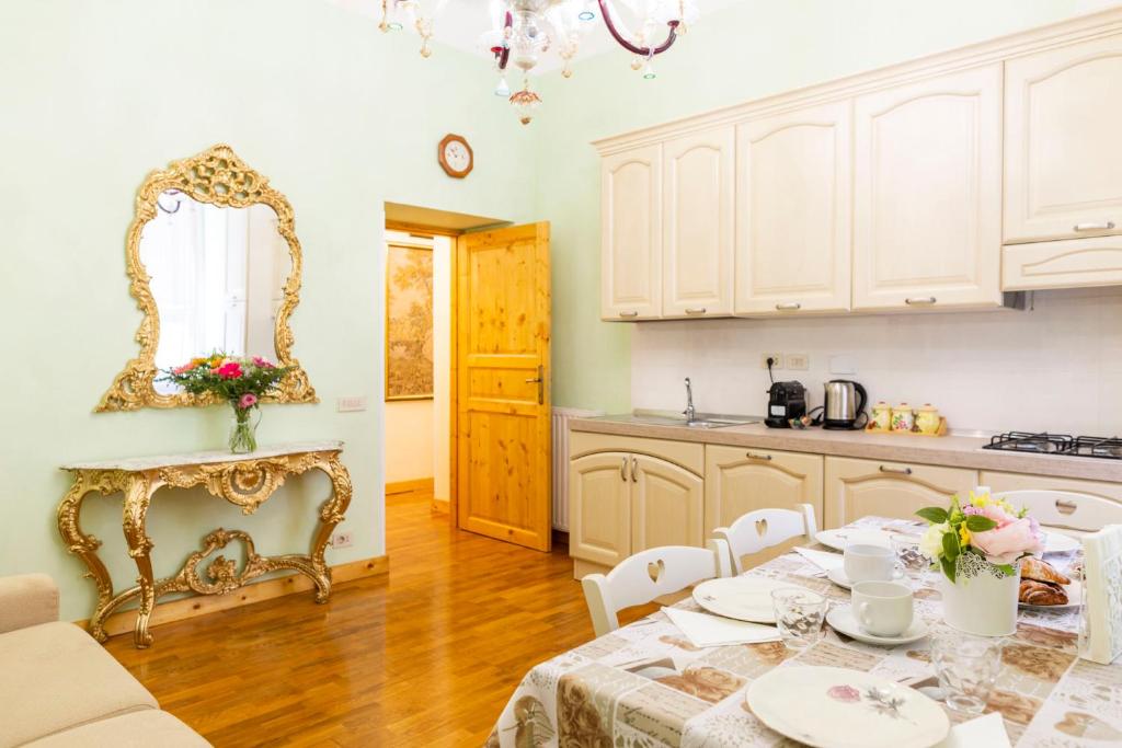 eine Küche mit einem Tisch und einem Spiegel an der Wand in der Unterkunft Rome Nico Apartment in Rom