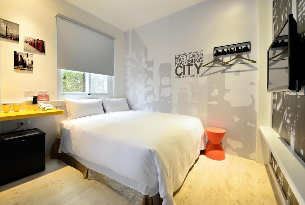 a bedroom with a white bed and a television at NL Concept Hotel in Kaohsiung