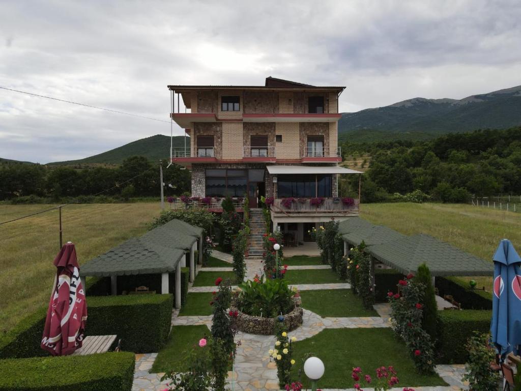 a large house with a garden in front of it at Hotel Restaurant Aleksander in Korçë