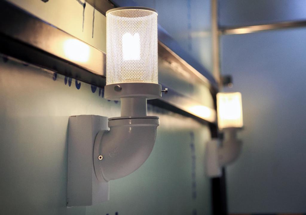 a bathroom with a toilet with a light on the wall at NL Concept Hotel in Kaohsiung