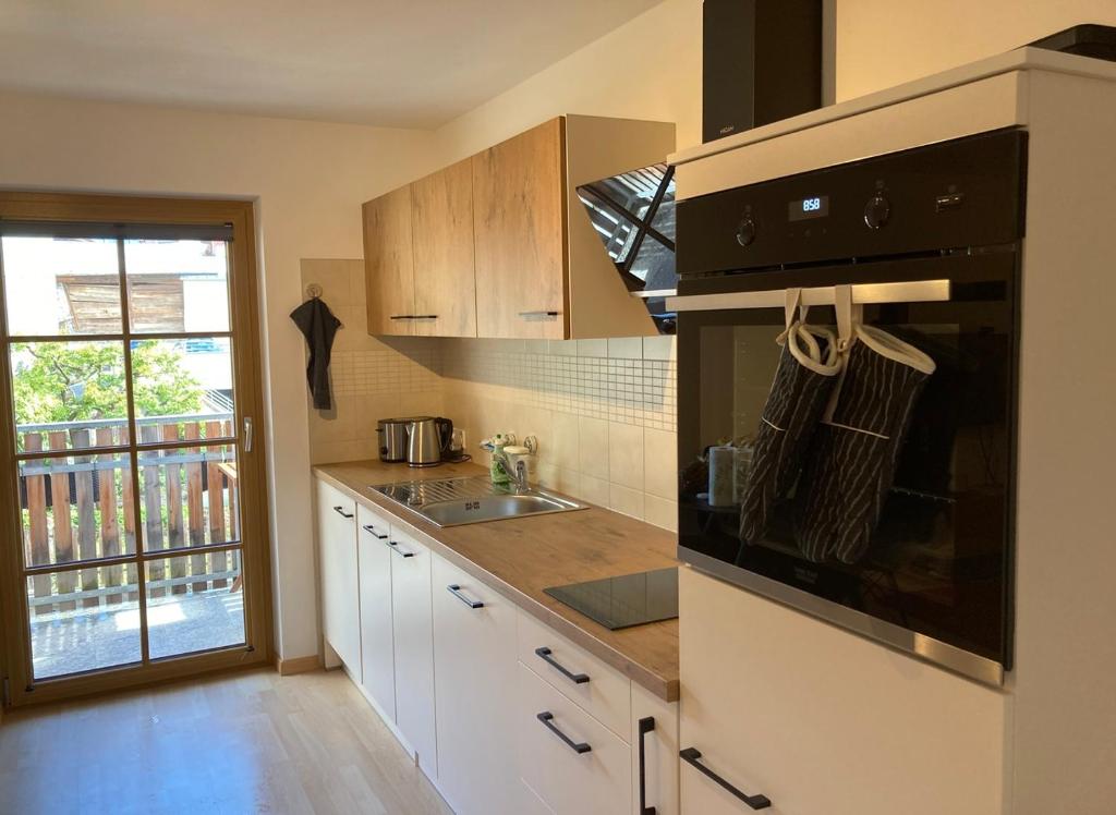 una cucina con lavandino e piano cottura forno superiore di Apart Vinschgau a Malles Venosta