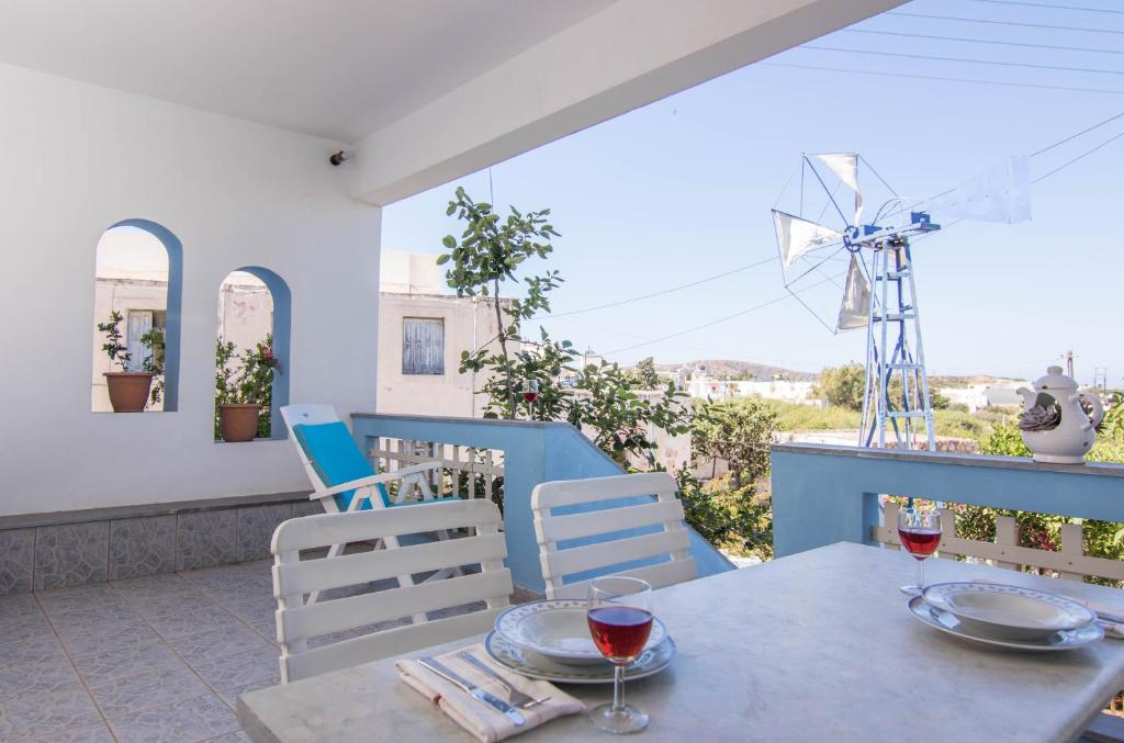 a table with two glasses of wine and a windmill at Fedra Apartments, View, Free Parking, 2mins to Beach in Palekastron