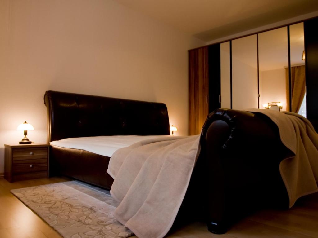 バーデン・バーデンにあるMaria-Viktoria Apartmentのベッドルーム1室(黒いヘッドボード付きのベッド1台付)