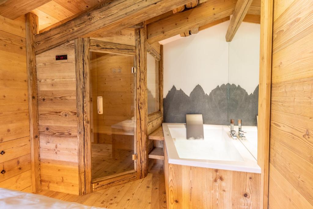 - une salle de bains dans une cabane en rondins avec lavabo dans l'établissement Lino Deluxe Suite, à Borca di Cadore