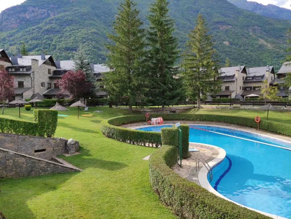 a resort with a large swimming pool in a yard at Apartamento de la Marmota in Eriste