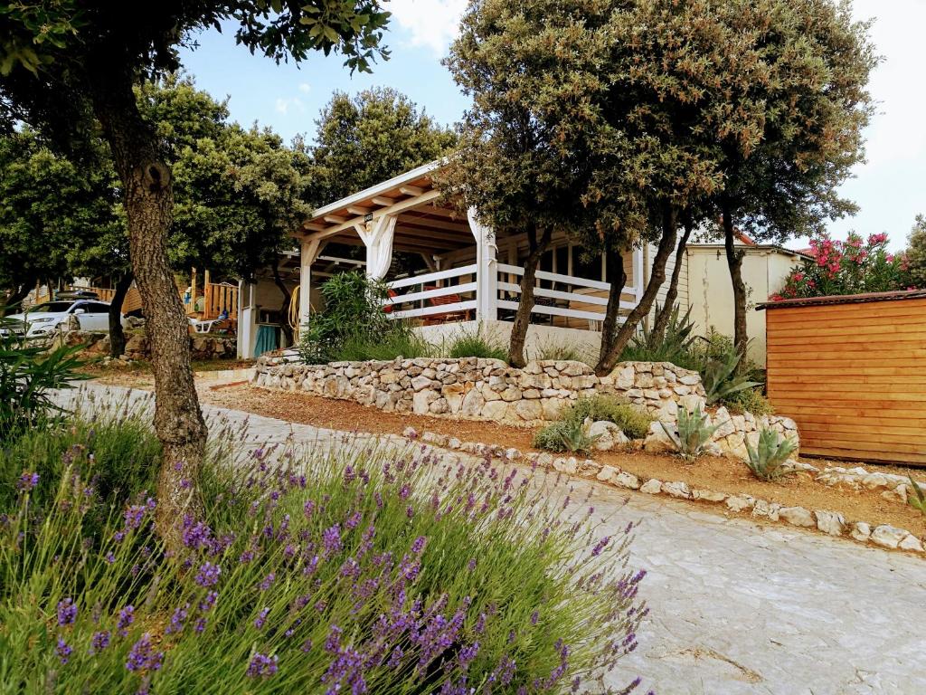 un jardín con una pared de piedra y una casa en Mobile homes Marita en Šimuni