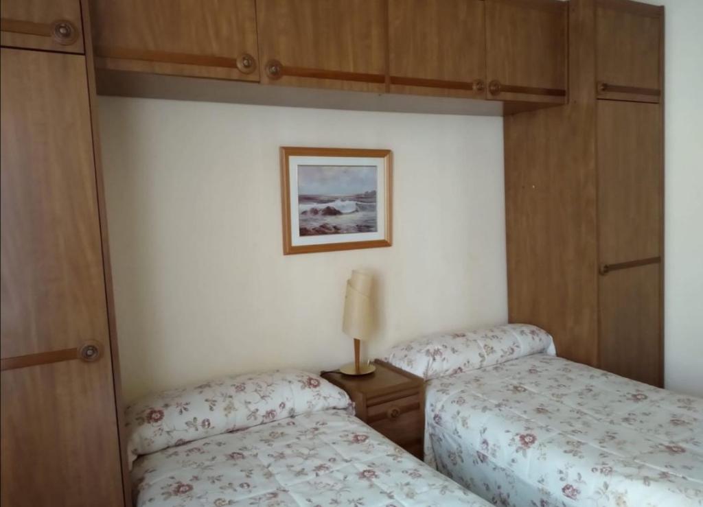 - une chambre avec 2 lits et une photo sur le mur dans l'établissement Apartamento Santo Domingo de la Calzada La Rioja, à Santo Domingo de la Calzada