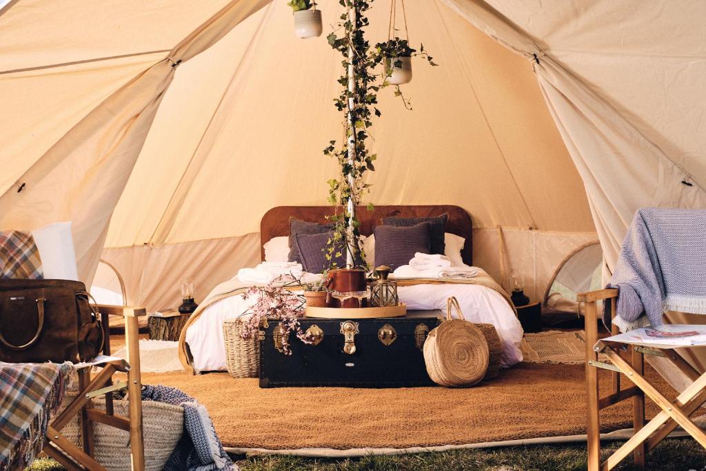 une tente avec un lit et une table. dans l'établissement The Quaives - Cottages & Glamping, à Canterbury