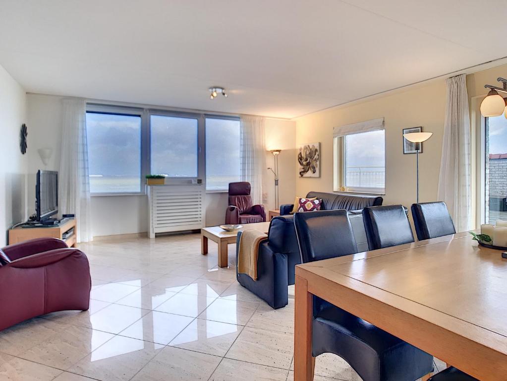 ein Wohnzimmer mit einem Sofa und einem Tisch in der Unterkunft Hello Zeeland - Appartement Port Scaldis 03-072 in Breskens