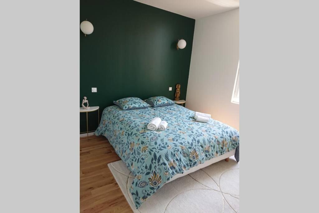 een slaapkamer met een bed met een groene muur bij T2 calme et design quartier Chartrons à Bordeaux in Bordeaux