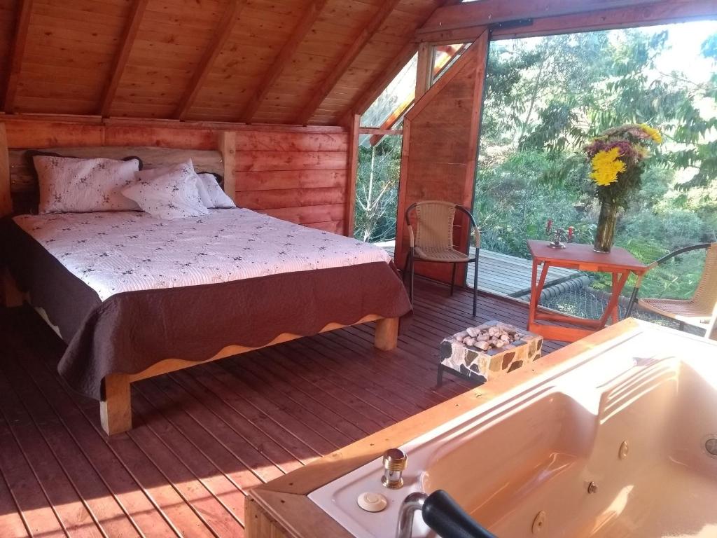 1 dormitorio en una cabaña con cama y bañera en Cabaña Arrayanes, en Rionegro