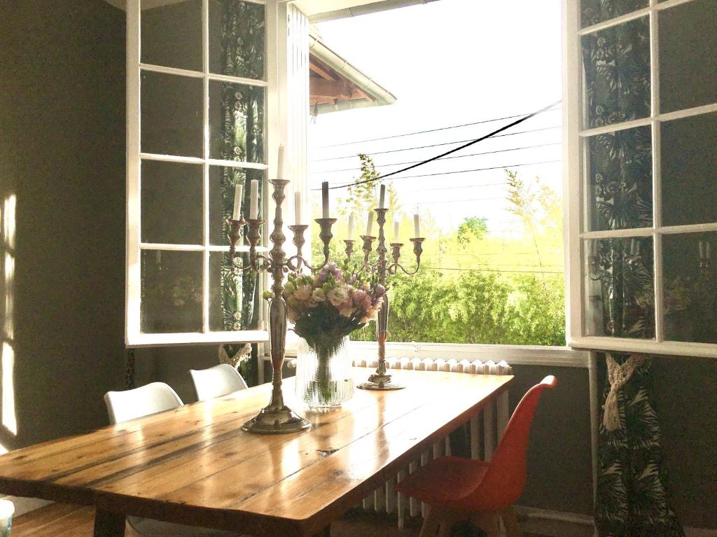 une table à manger avec un vase de fleurs et des bougies dans l'établissement R & R BERGERAC, à Bergerac