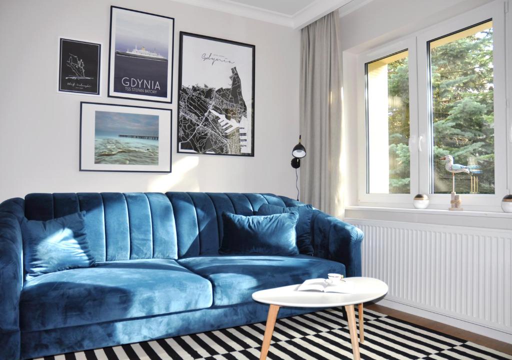 a blue couch in a living room with a table at Bulwar Gdynia in Gdynia