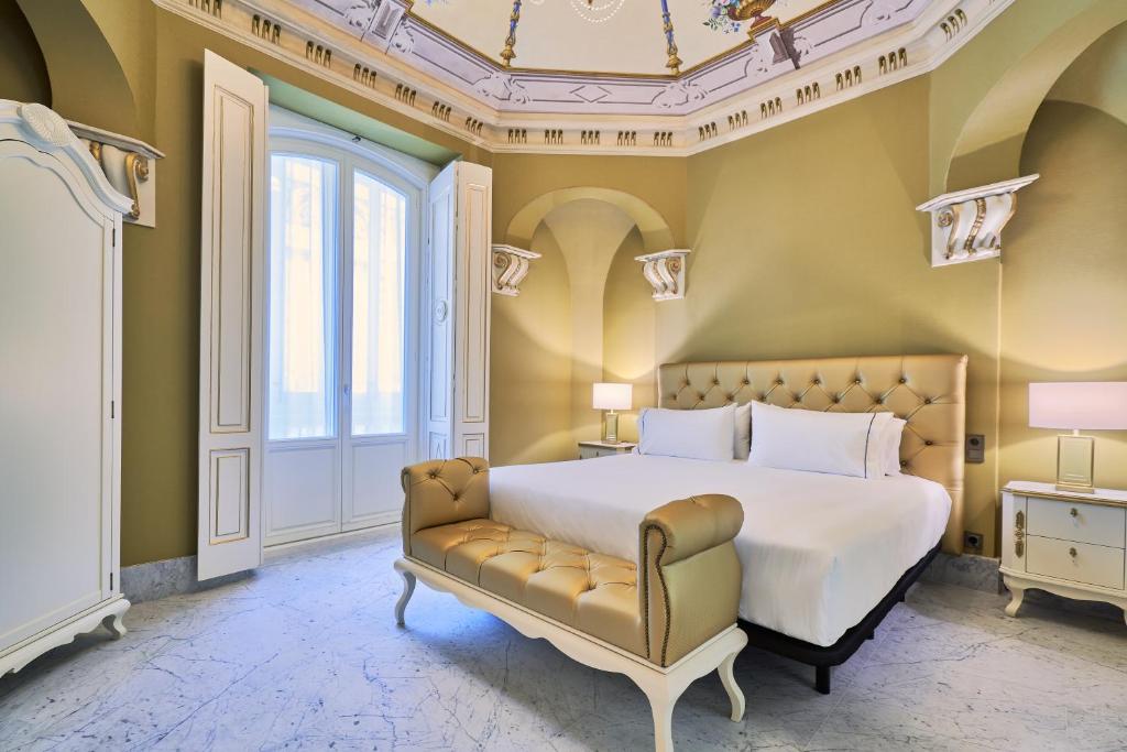 1 dormitorio con 1 cama y 1 sofá en Tandem Palacio Veedor de Galeras Suites en Cádiz